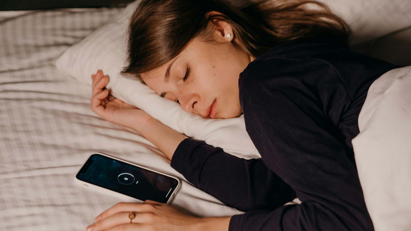 a woman sleeping beside her smartphone