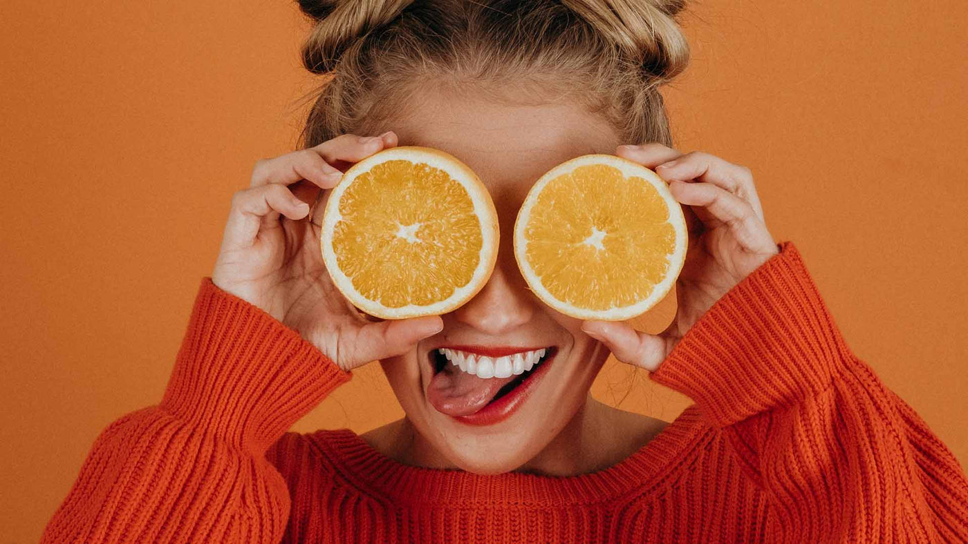 woman in red knit sweater holding lemon