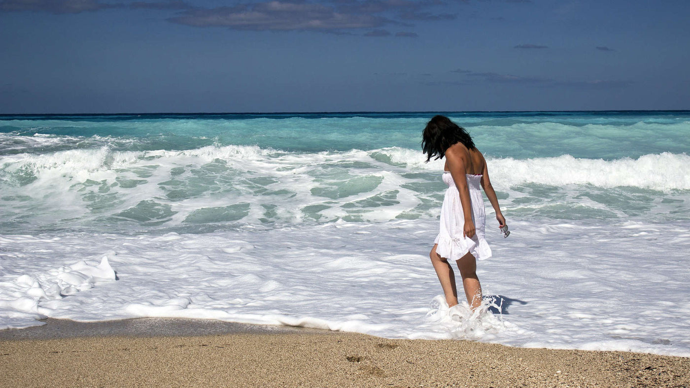 a woman in a white dress on the beach